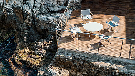 SeaX von Dedon ist ein Klappstuhl mit Stil. Perfekt für jeden Outdoorbereich, egal ob Balkon, Terrasse oder eine schöne Yacht. Passend zum Stuhl gibt es einen klappbaren Hocker sowie Esstische und Kaffeetische. Jetzt bei Ihrem Dedon Händler in Wien - Grünbeck Einrichtungen.