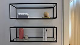 The CHRISTINE KRÖNCKE Cameo wall shelves in Black Edition with glass inserts are available at Grünbeck Einrichtungen as display items in the Design Sale at a reduced price.