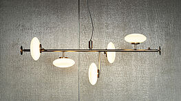 Mami—the Penta pendant lamp with white oval glass bodies and bronze metal frame—a collection for pendant and table lamps—available from Grünbeck Vienna