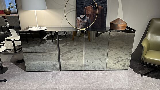 The Interlübke Jorel Reflect sideboard with drawers and hinged doors and with fronts and top made of sepia mirror is now available at Grünbeck Einrichtungen in the design sale at a reduced price.