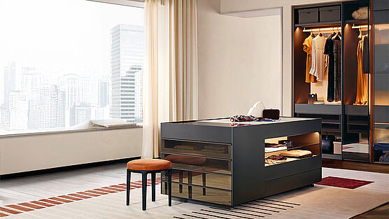 Poliform Set Up ist eine Insel-Kommode mit offenen Fächern, Schubladen und einer Glasplatte - bedienbar von allen 4 Seiten. Erhältlich bei Grünbeck Einrichtungen Wien